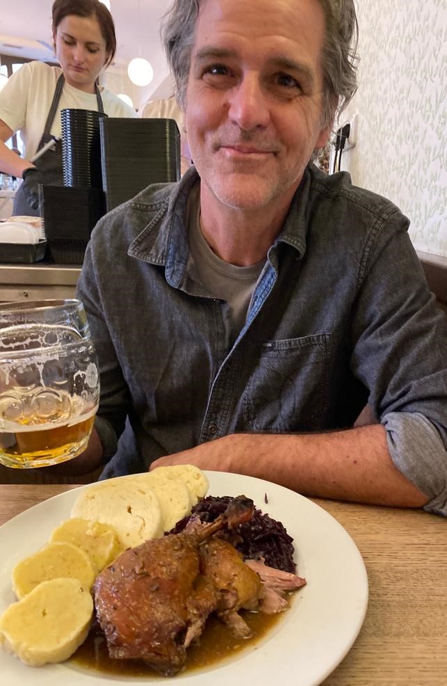 Program director David Hicks eating a meal in Prague, Czech Republic: dumplings, duck, cabbage, and pilsner.