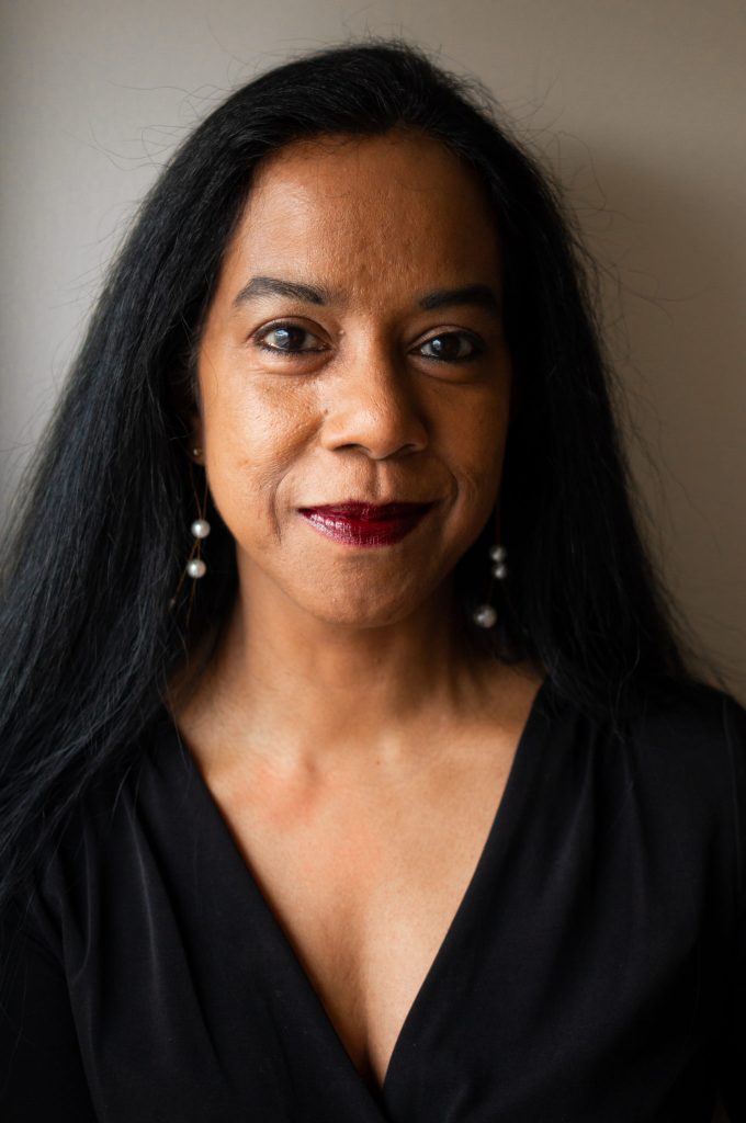 Headshot of writer Ru Freeman, smiling softly and wearing a black top.
