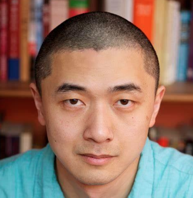 Profile of Ken Liu with bookshelves in the background.