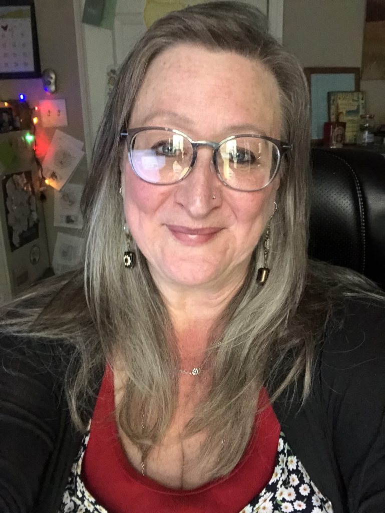 Headshot of Brenda Fager smiling with glasses on.